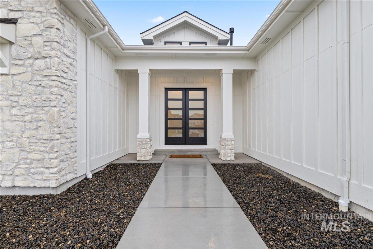 Entrance to property with stone siding and board and batten siding