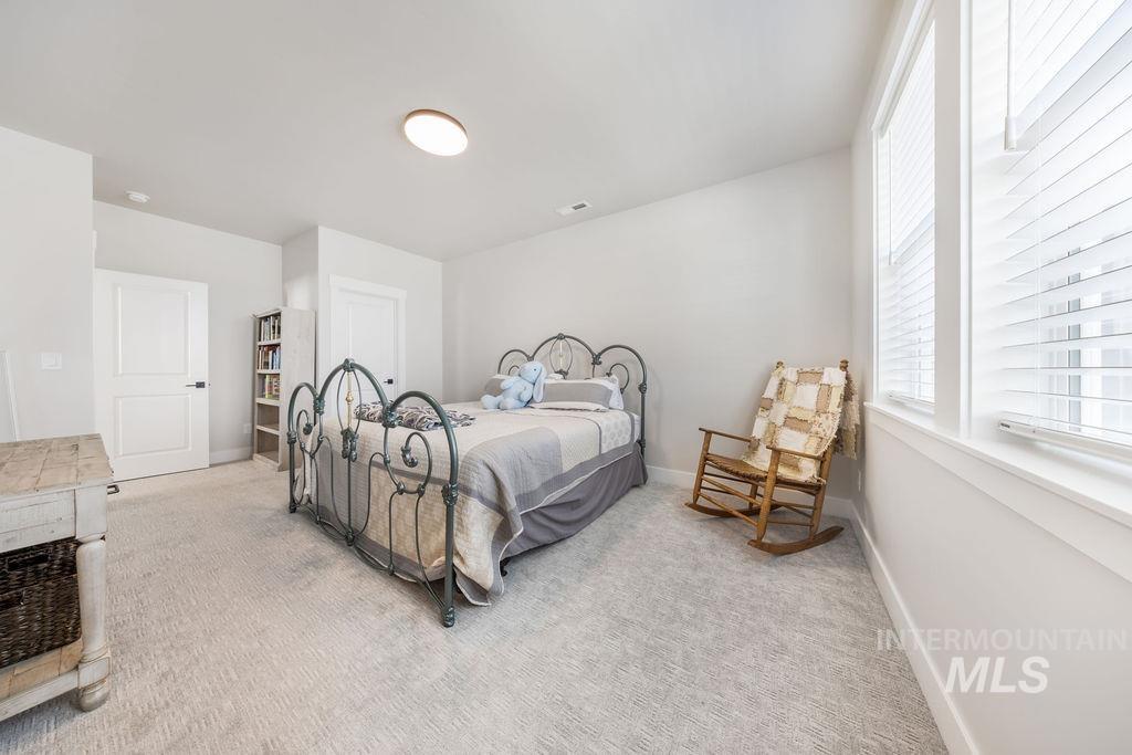 Bedroom featuring light colored carpet and baseboards