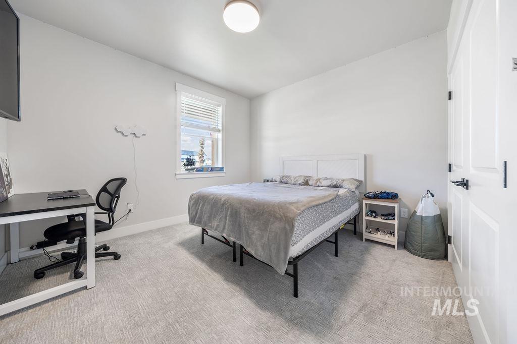 Bedroom with an office area and light colored carpet