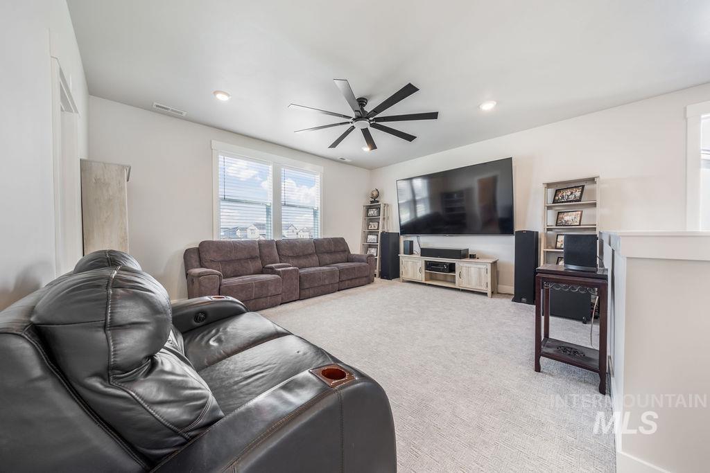Living room featuring light carpet, a ceiling fan, and recessed lighting