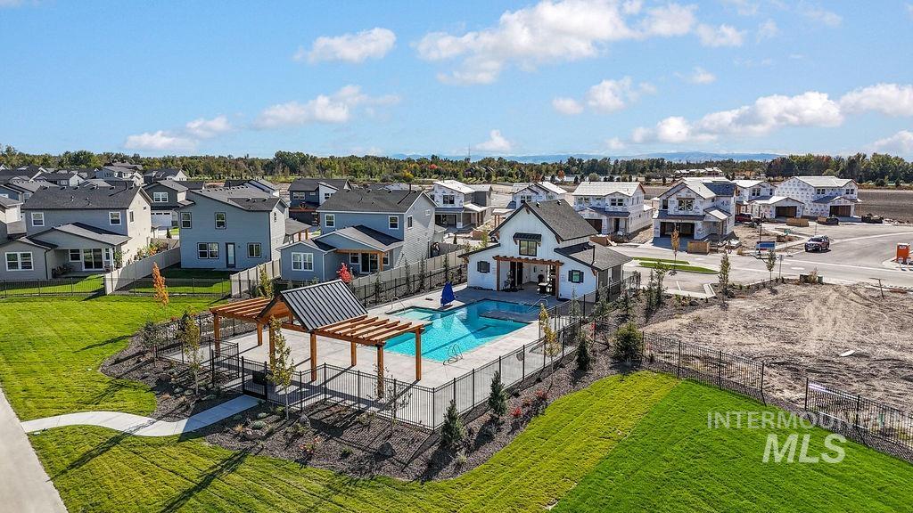 View of pool featuring a patio area, a fenced backyard, and a residential view