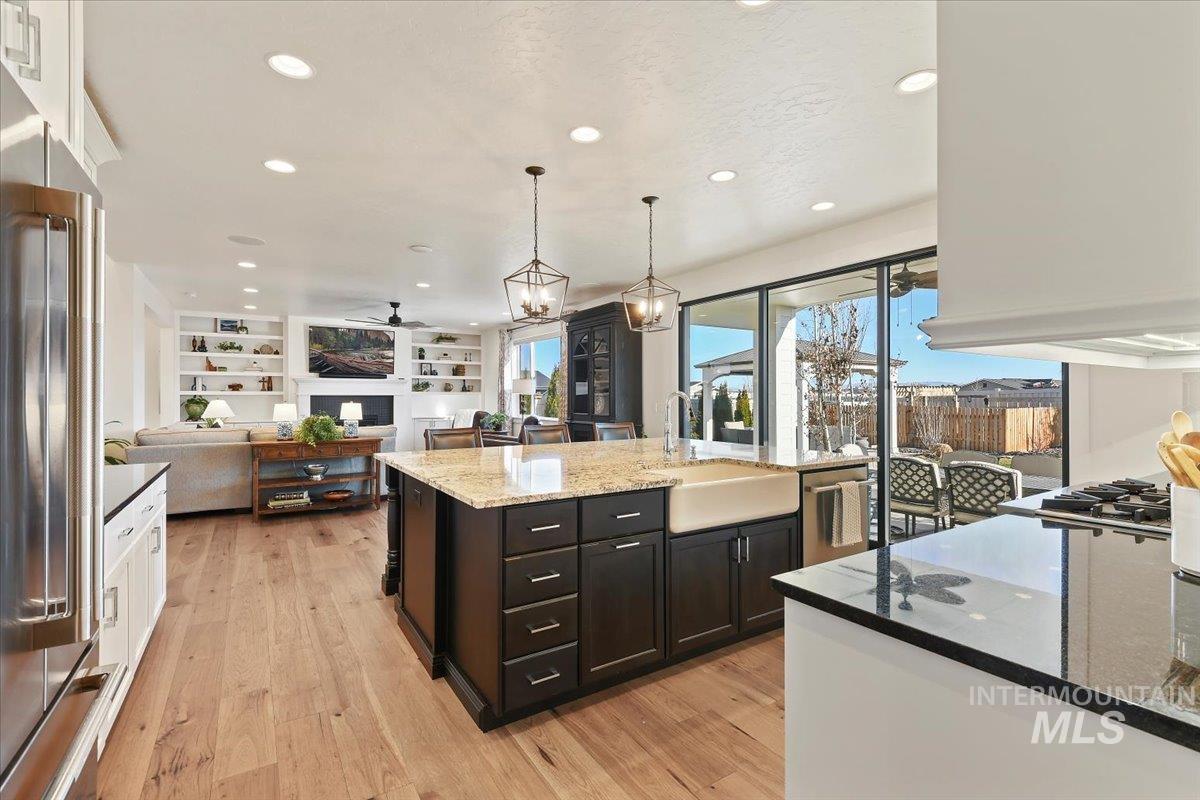 Kitchen with dark stone countertops, recessed lighting, pendant lighting, white cabinetry, and stainless steel appliances