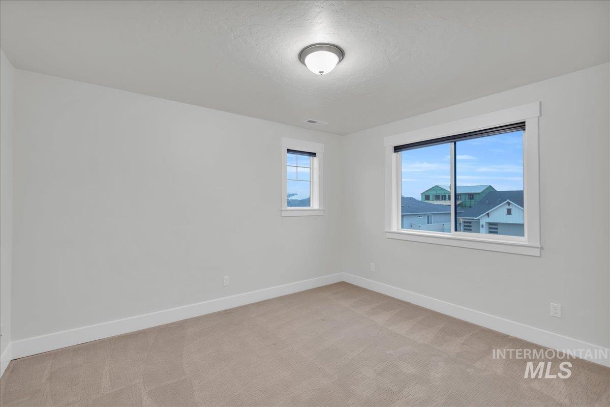 Unfurnished room featuring light colored carpet and a textured ceiling