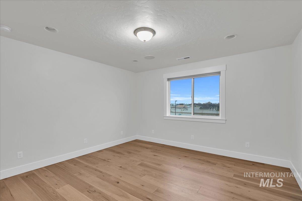 Empty room featuring a textured ceiling and light wood-style flooring