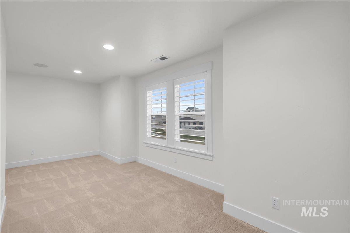 Unfurnished room with light colored carpet and recessed lighting