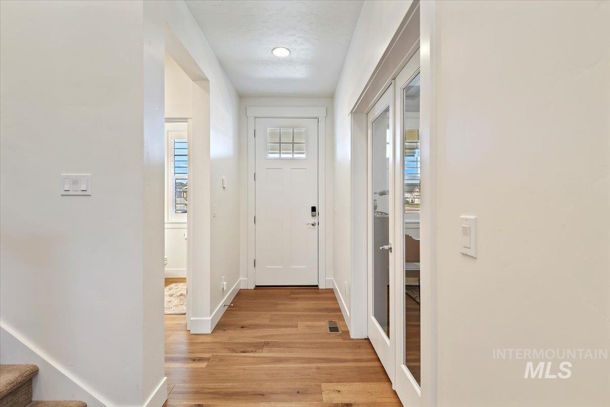 Doorway to outside with wood finished floors and stairs