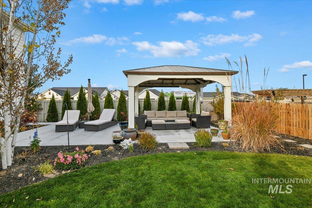 Fenced backyard with a gazebo, a patio area, and an outdoor hangout area