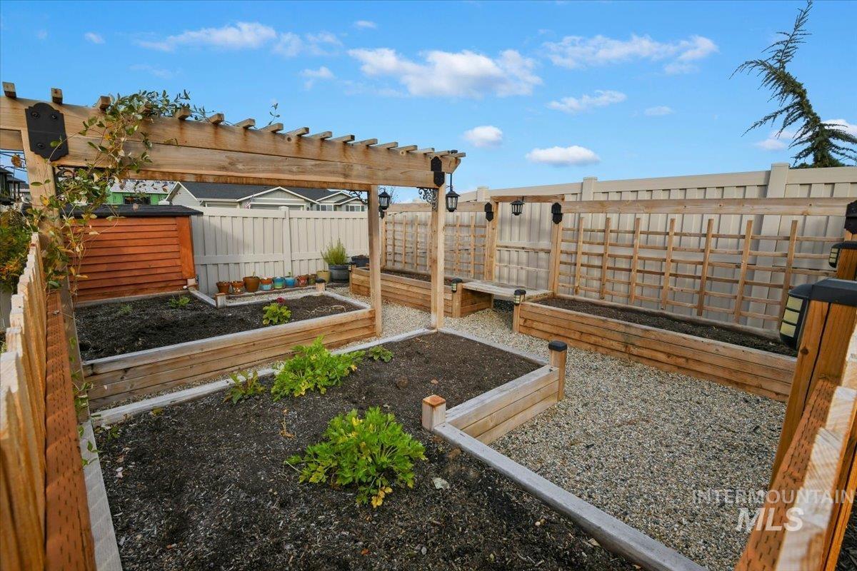 Fenced backyard with a garden and a pergola