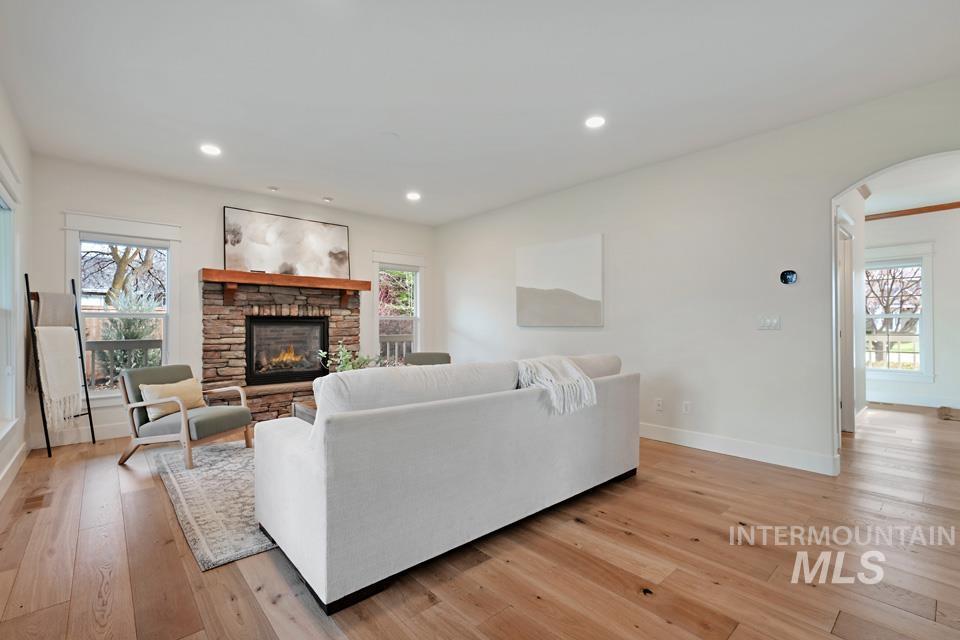 Living area with healthy amount of natural light, light wood-style flooring, arched walkways, and recessed lighting