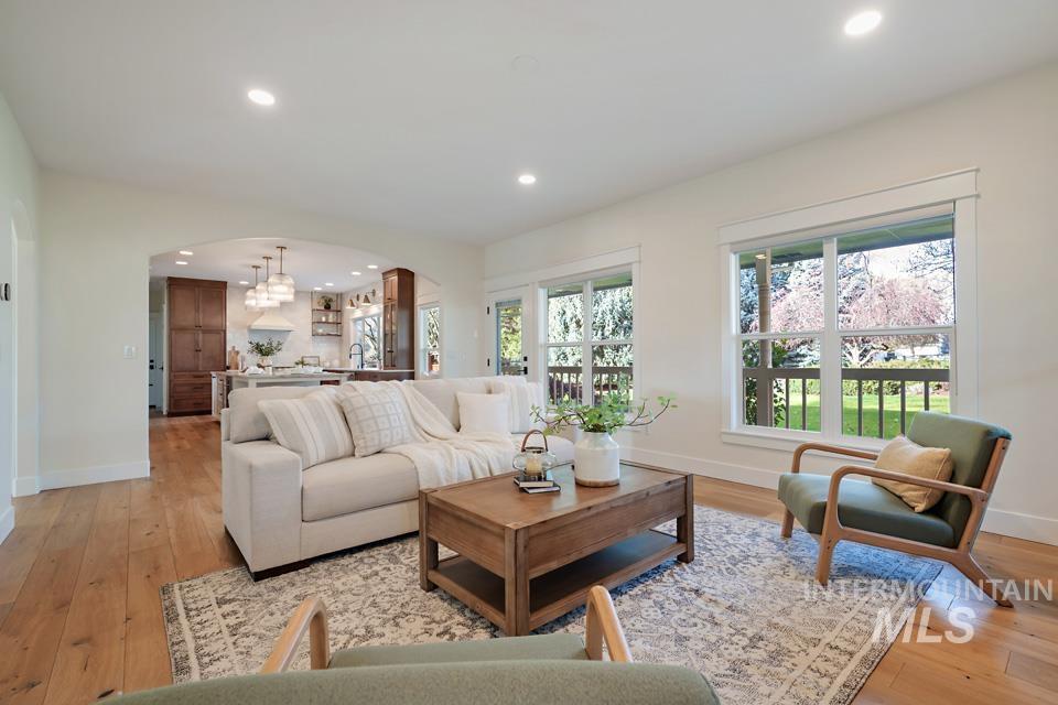Living room featuring arched walkways, recessed lighting, and light wood finished floors