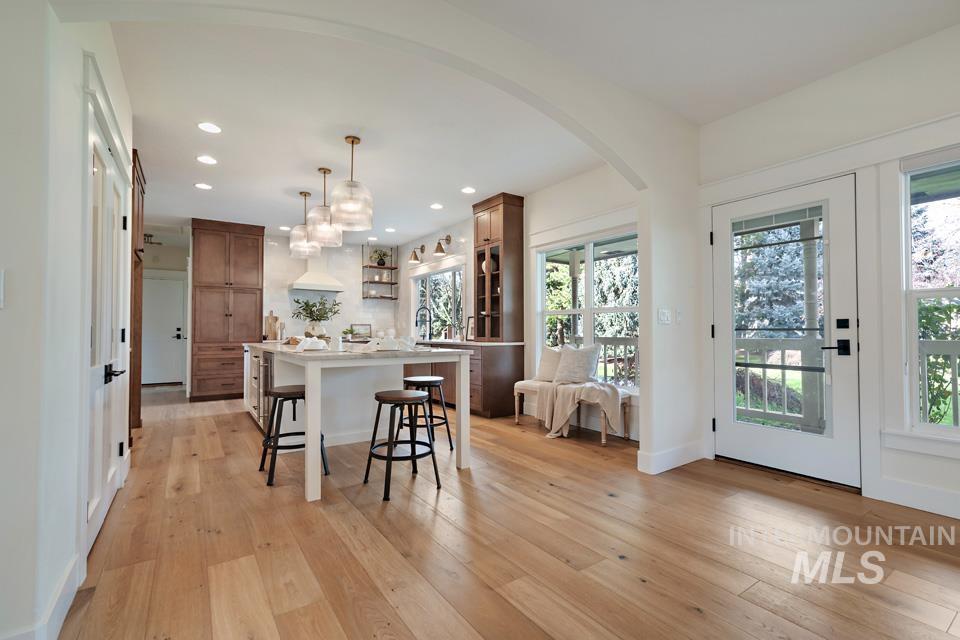Kitchen with a kitchen breakfast bar, arched walkways, a kitchen island, recessed lighting, and open shelves