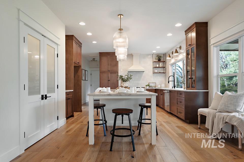 Kitchen featuring open shelves, brown cabinets, a kitchen breakfast bar, a center island, and recessed lighting