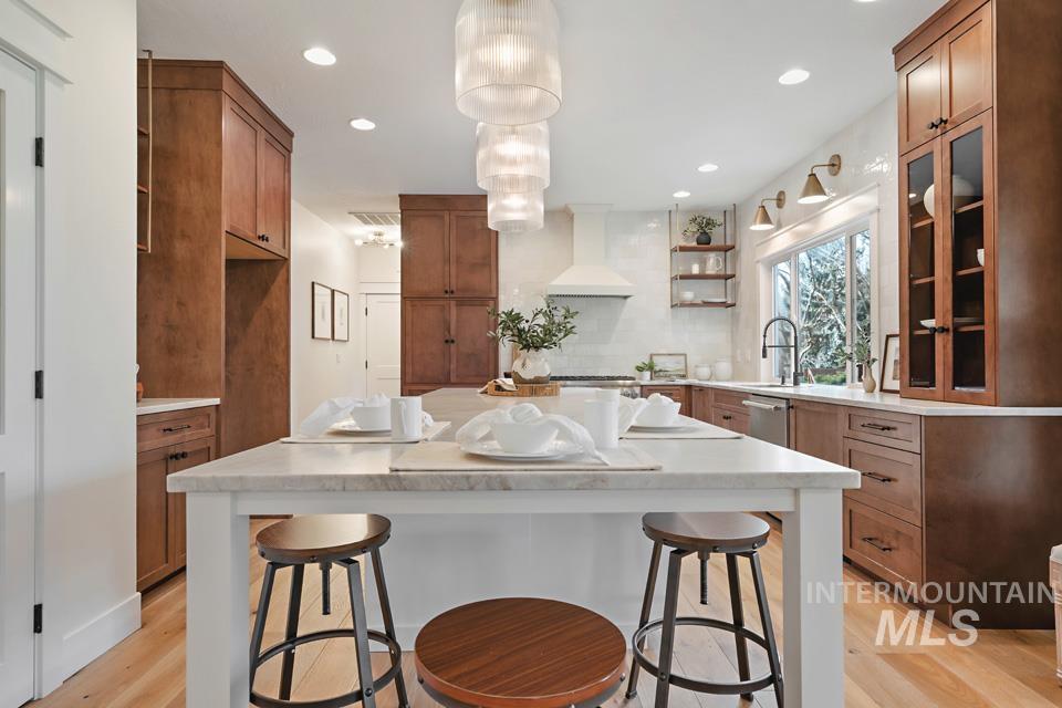 Kitchen with open shelves, a breakfast bar, brown cabinets, and recessed lighting