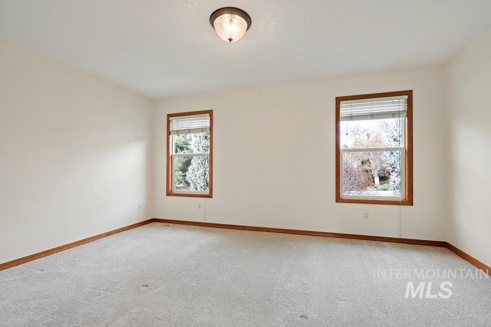 Carpeted spare room with baseboards