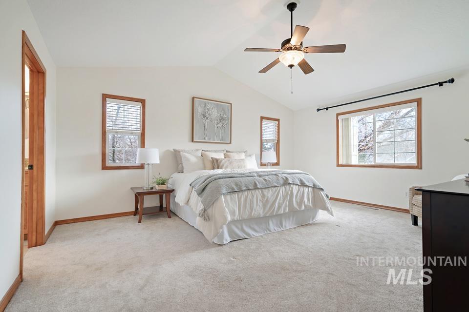 Bedroom with vaulted ceiling, ceiling fan, and light colored carpet