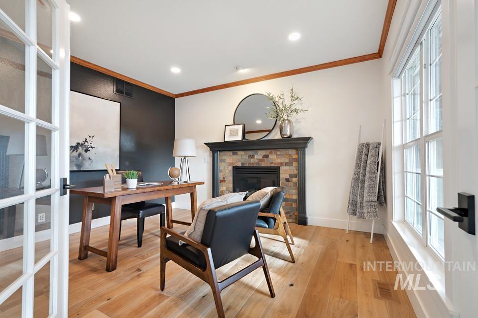 Home office featuring light wood-style flooring, ornamental molding, a fireplace, and recessed lighting