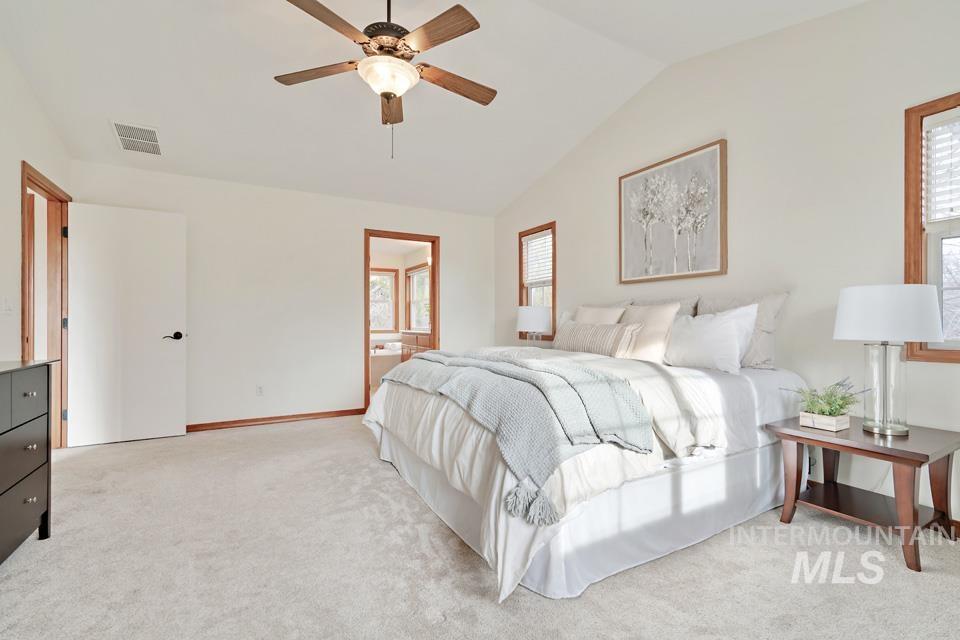 Bedroom with lofted ceiling, light carpet, and a ceiling fan