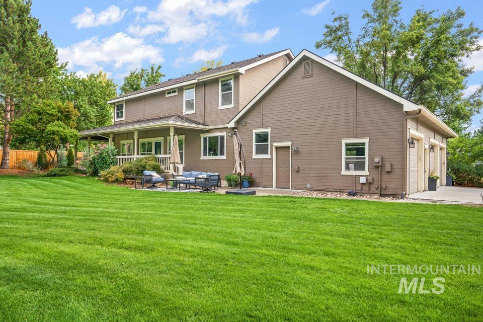Rear view of house featuring an outdoor living space, a patio area, an attached garage, and concrete driveway