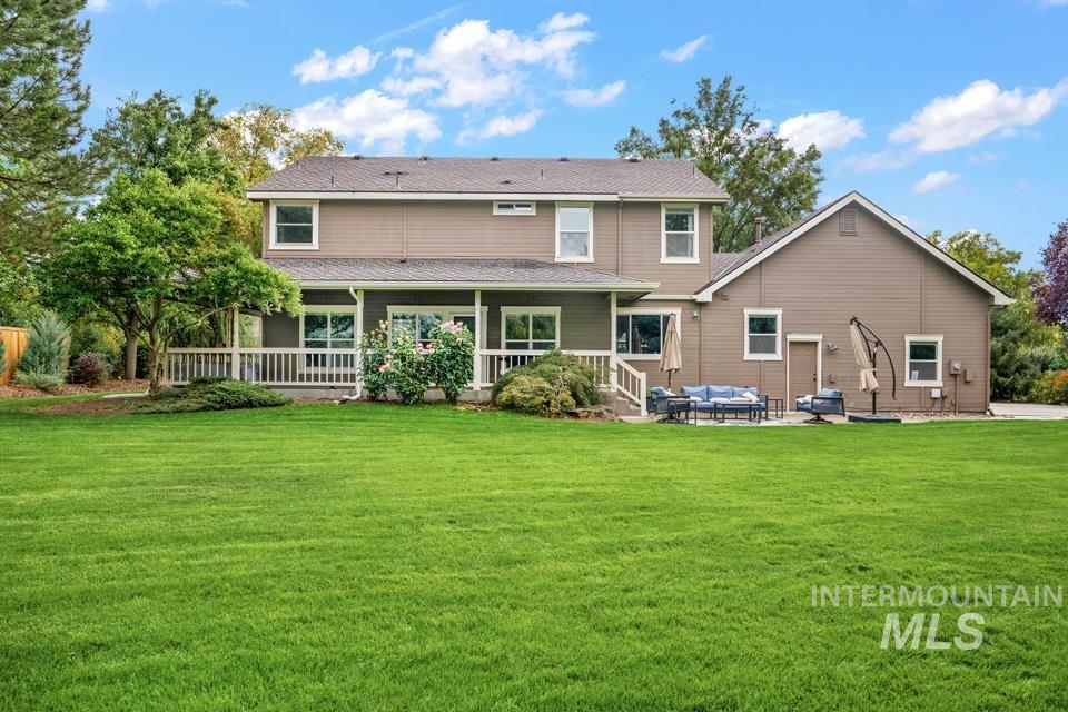 Rear view of property with a lawn, a patio area, outdoor lounge area, and covered porch