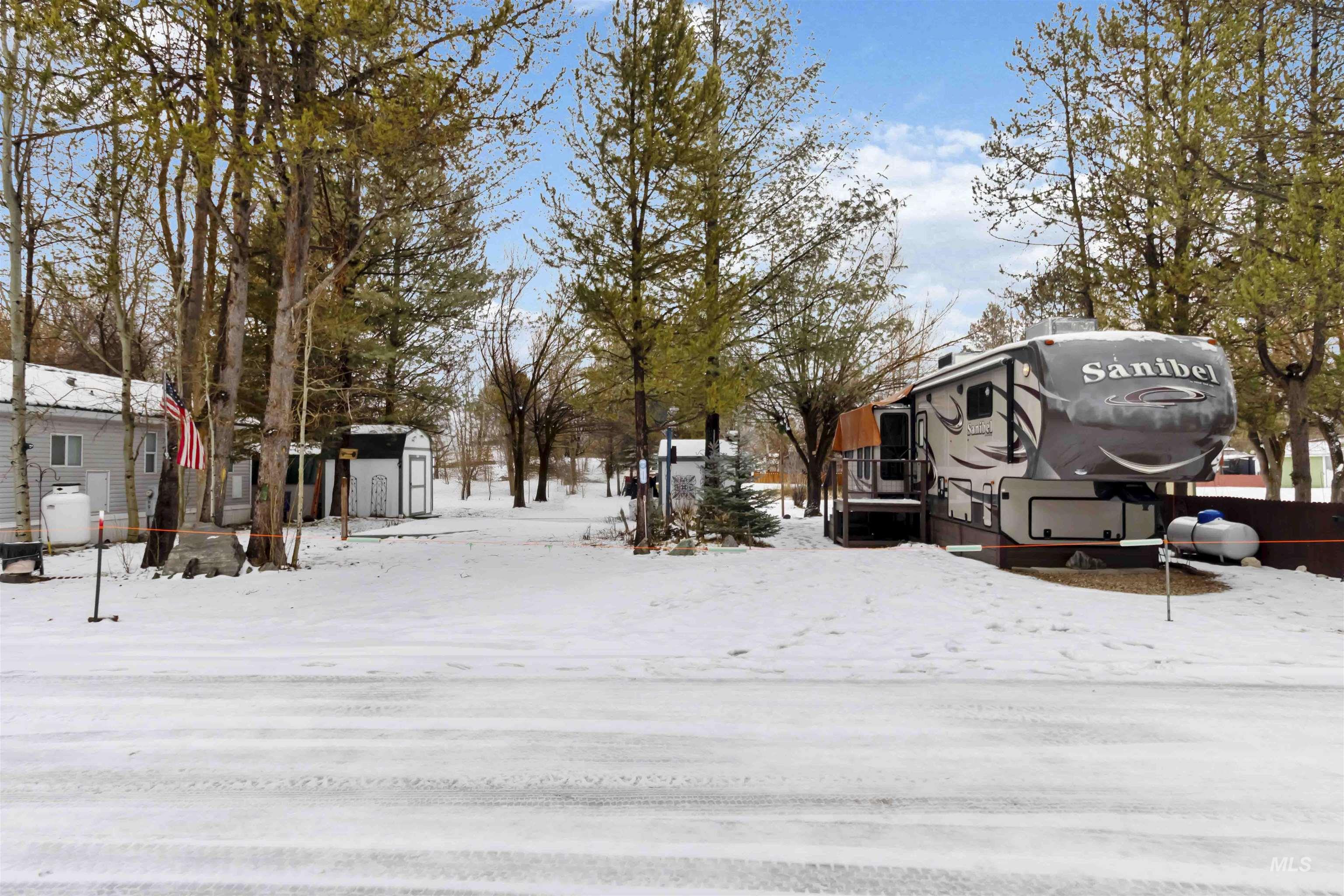 Yard layered in snow with a storage shed