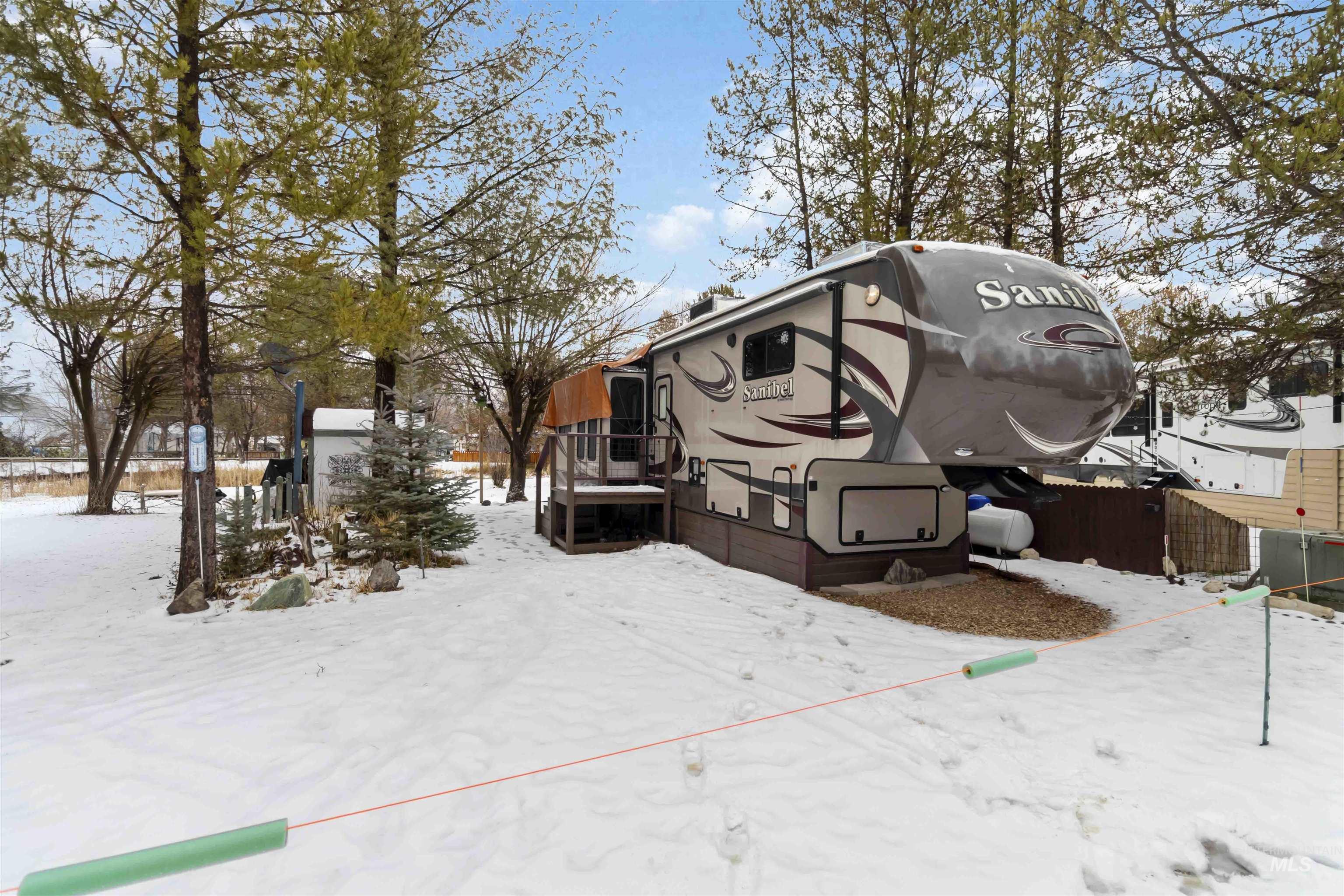 View of snow covered exterior with a wooden deck