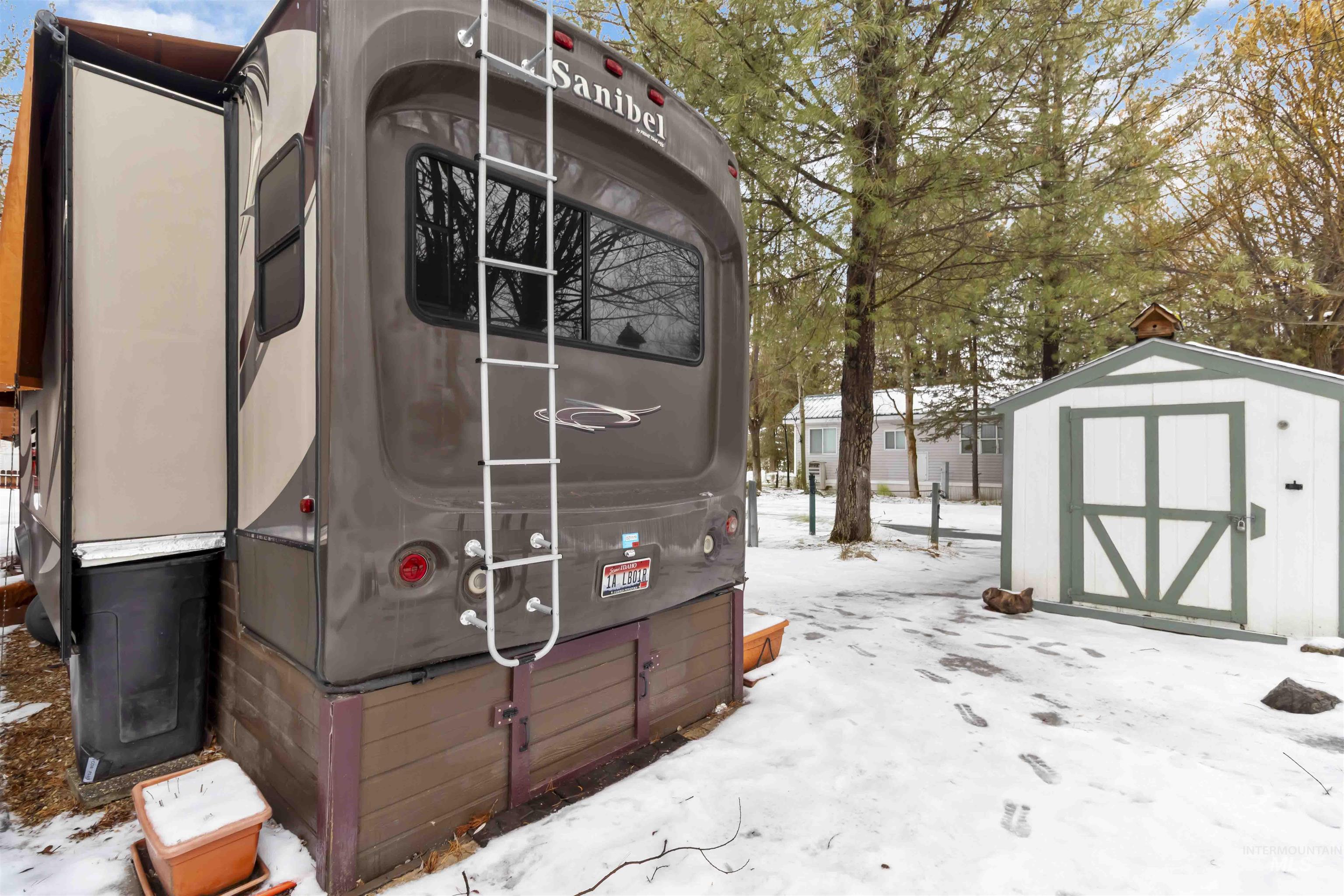Snow covered structure featuring a storage unit