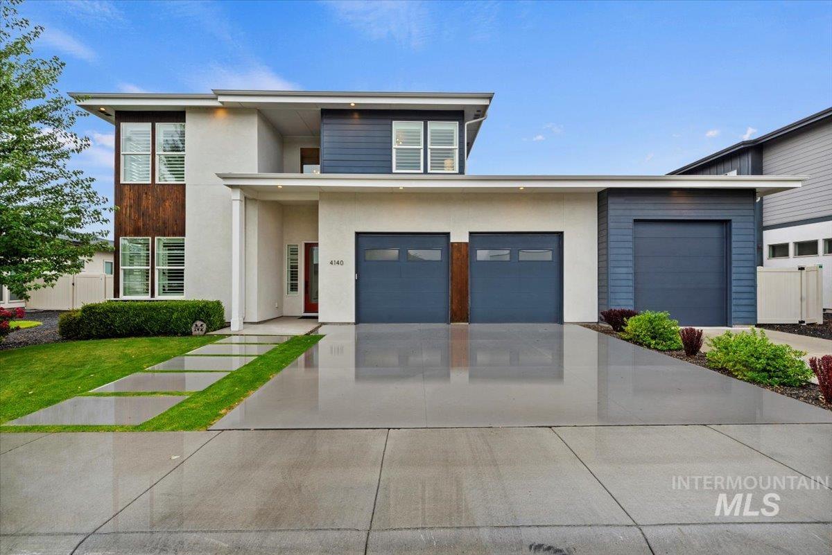 Prairie-style home featuring stucco siding and driveway