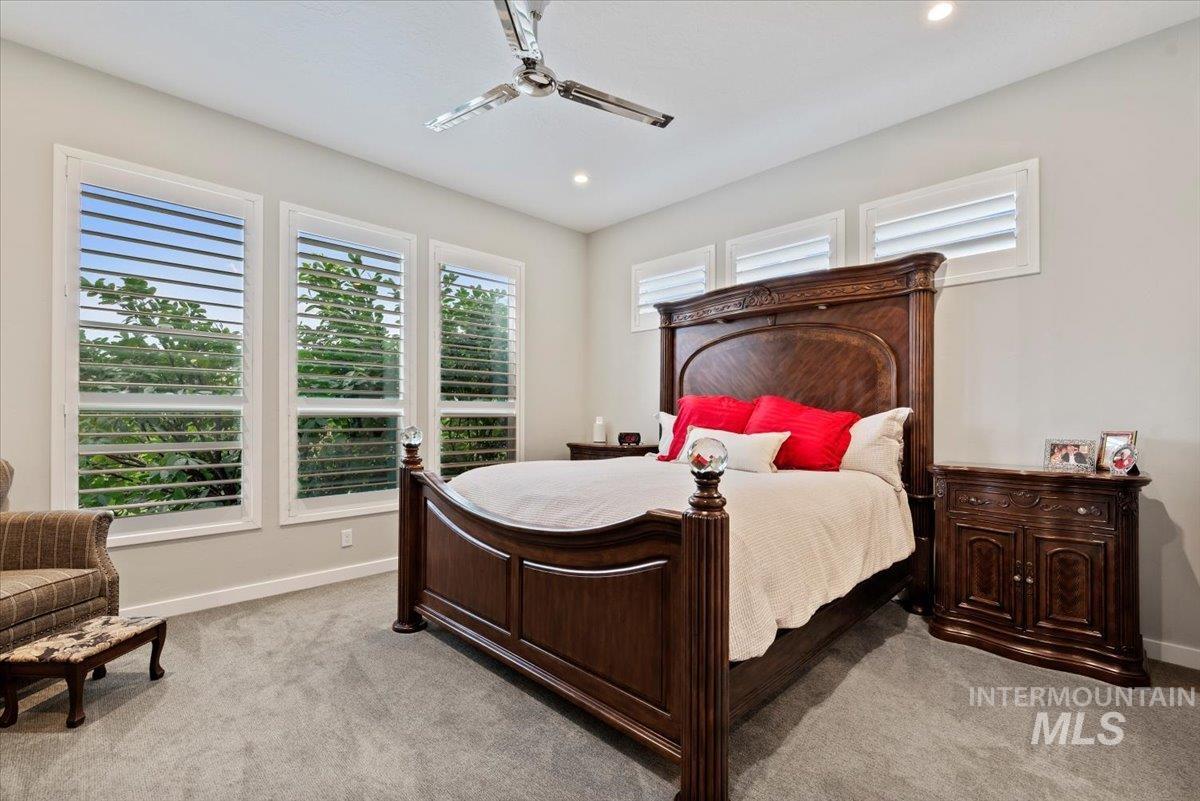 Bedroom featuring light colored carpet, ceiling fan, and recessed lighting