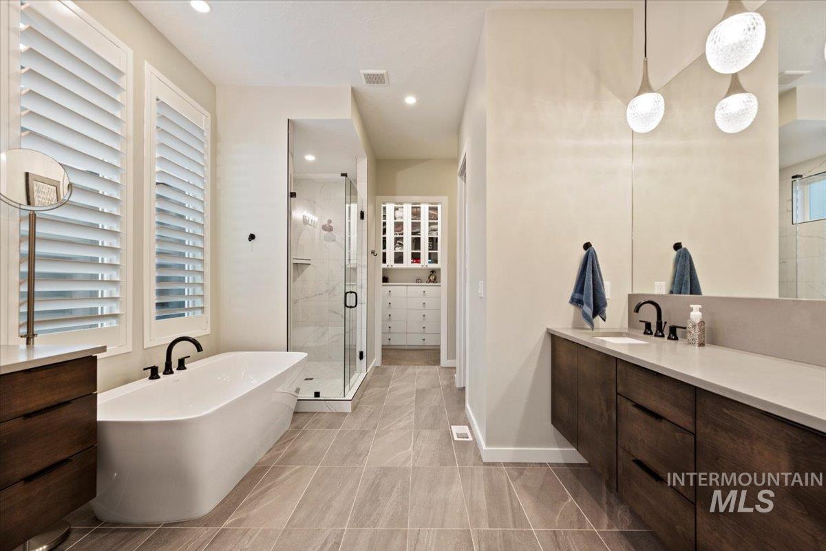 Full bath with vanity, a freestanding bath, a stall shower, recessed lighting, and a closet