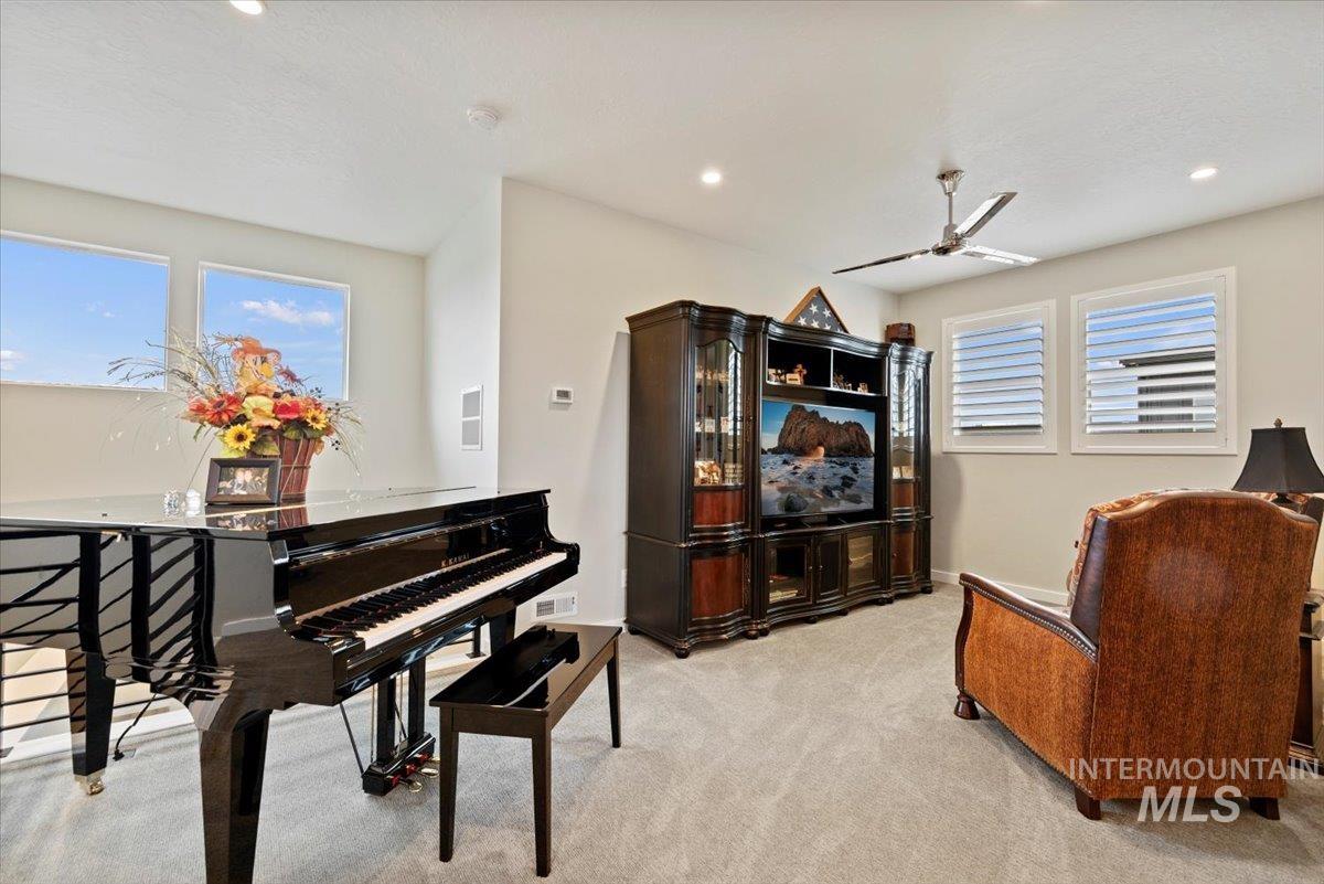 Sitting room with light carpet, healthy amount of natural light, a ceiling fan, and recessed lighting