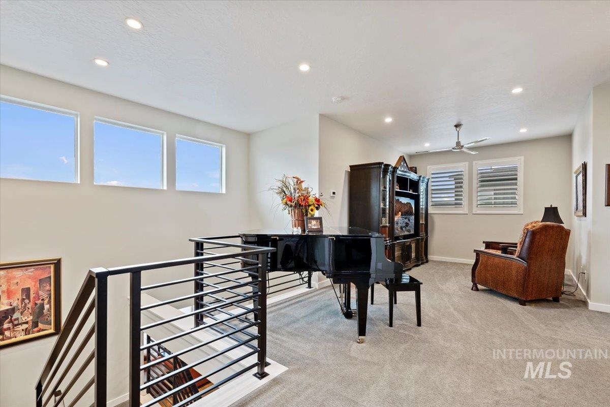 Sitting room featuring an upstairs landing, light carpet, recessed lighting, and ceiling fan