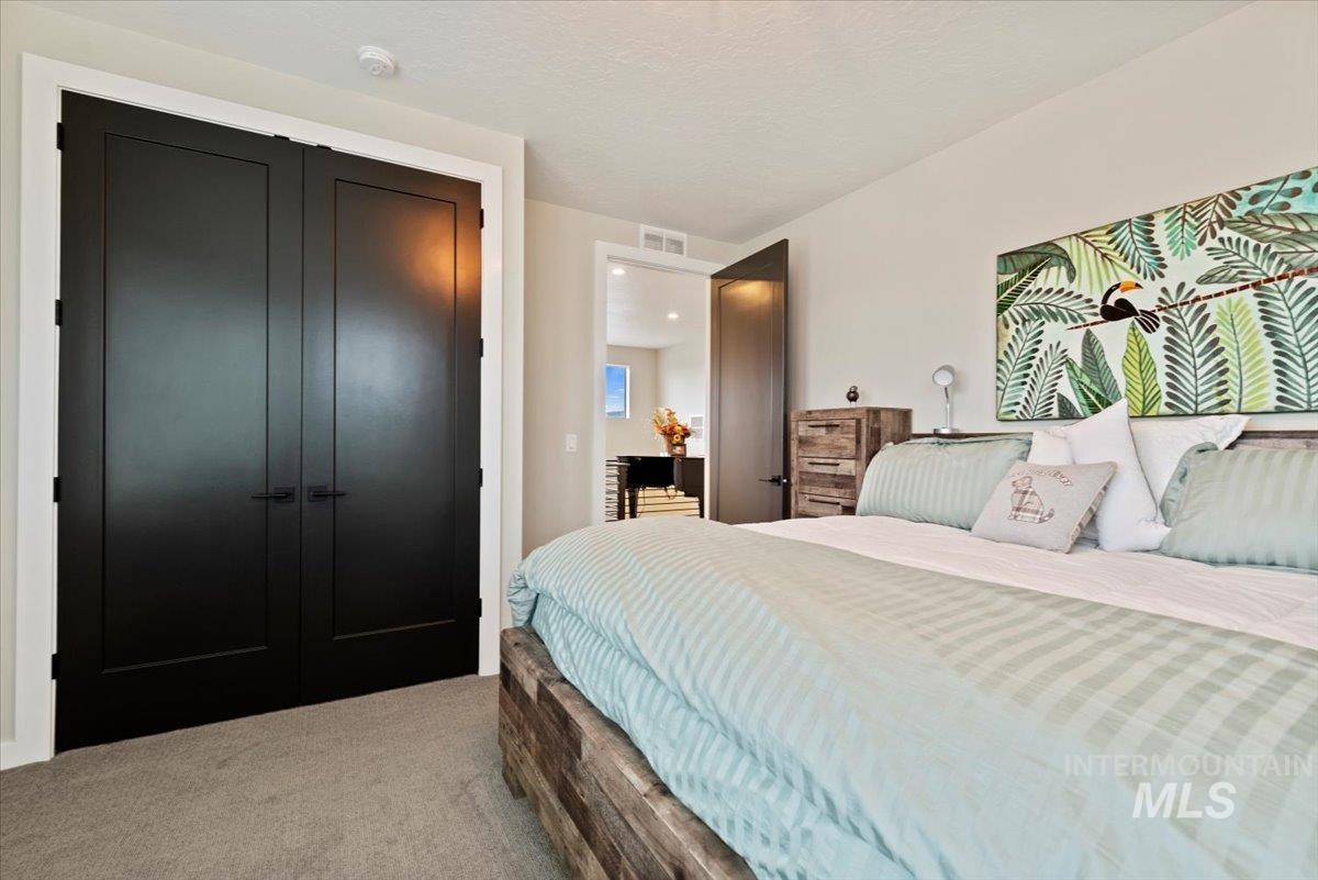 Carpeted bedroom with a closet