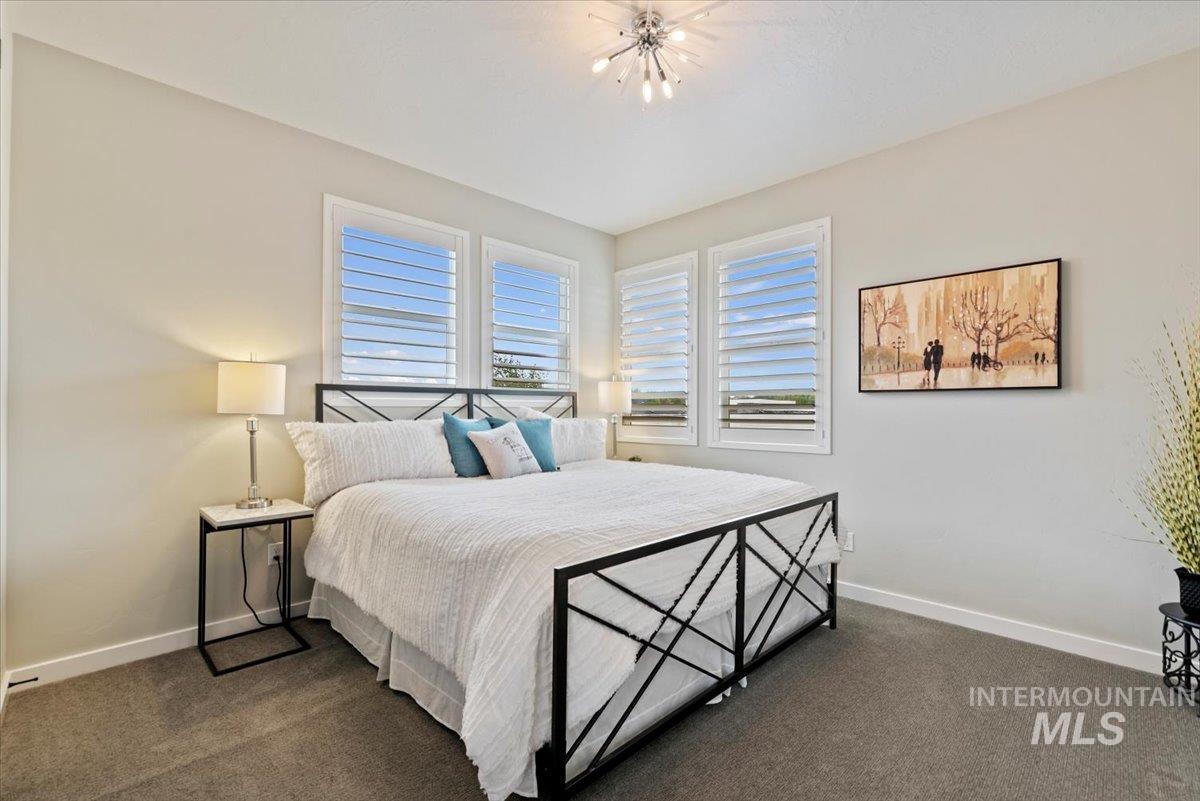 Bedroom with baseboards and dark colored carpet