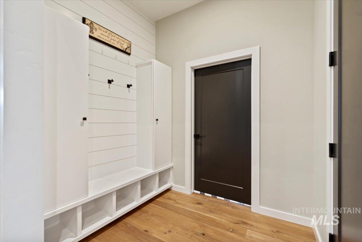 Mudroom with light wood-style flooring and baseboards