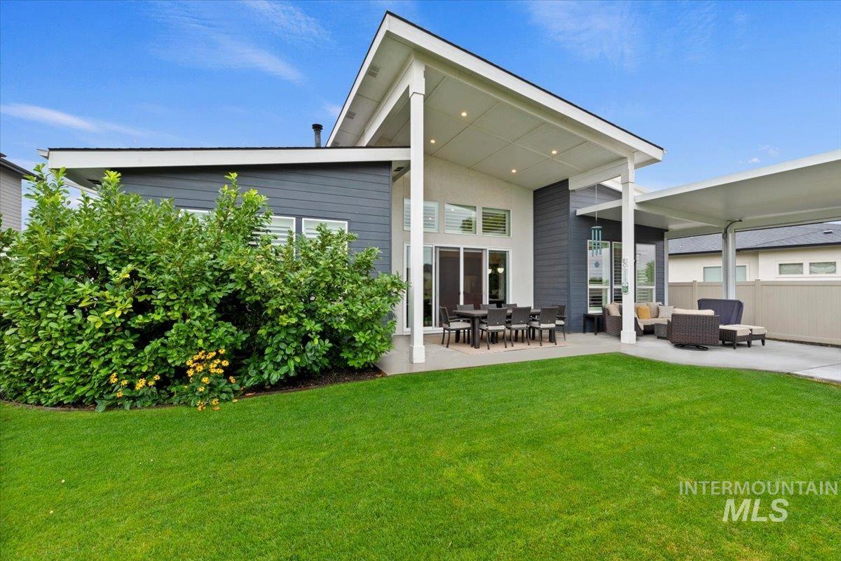 Back of property with a patio area, an outdoor hangout area, and a lawn