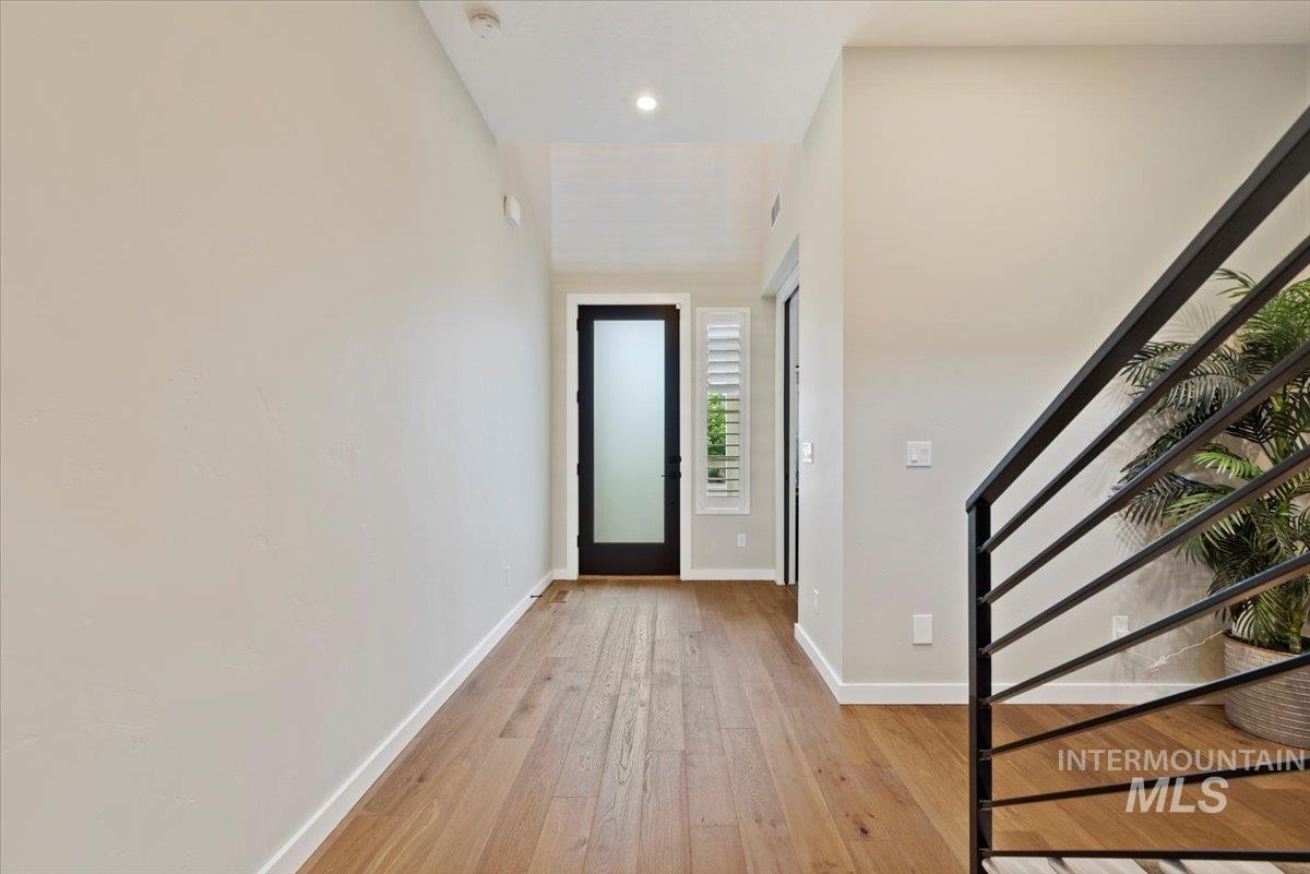 Foyer entrance featuring light wood finished floors, stairway, and recessed lighting