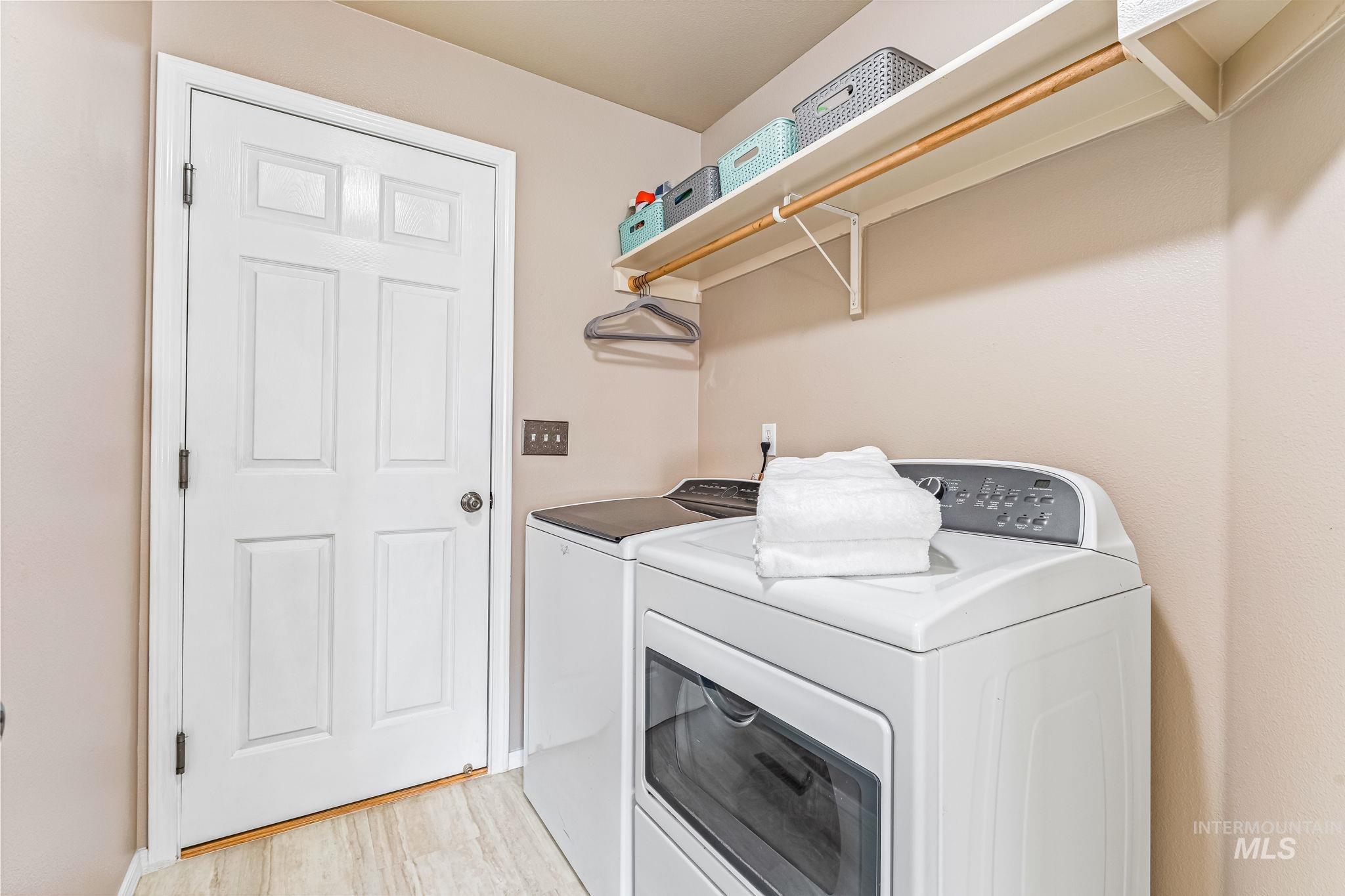 Washroom featuring washer and dryer and light wood-type flooring