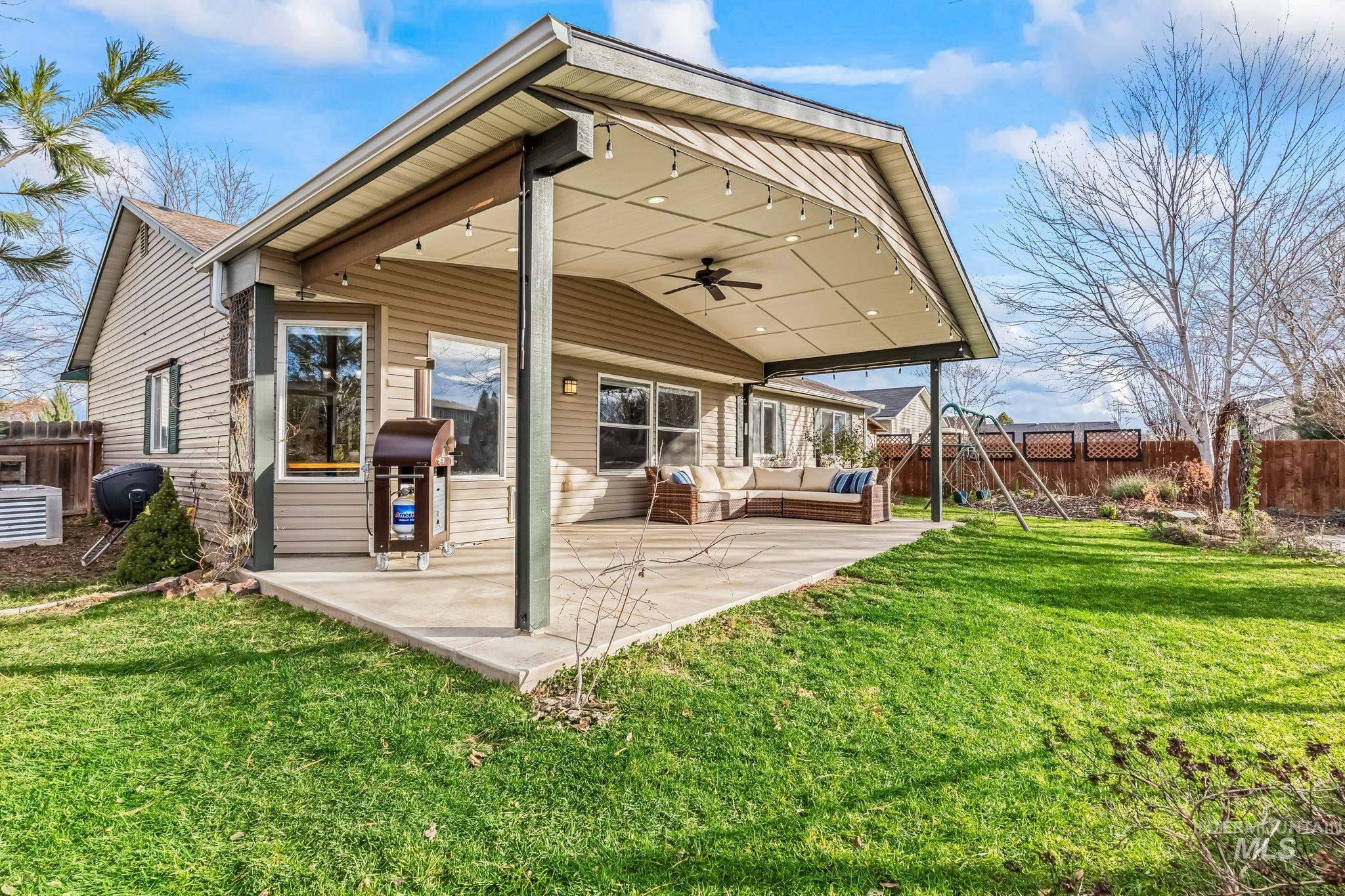 Rear view of property featuring ceiling fan, a fenced backyard, a patio area, and outdoor lounge area