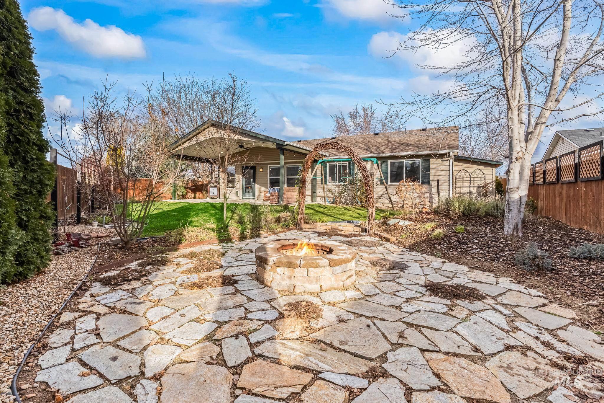 Rear view of property with a patio, a fenced backyard, and a fire pit