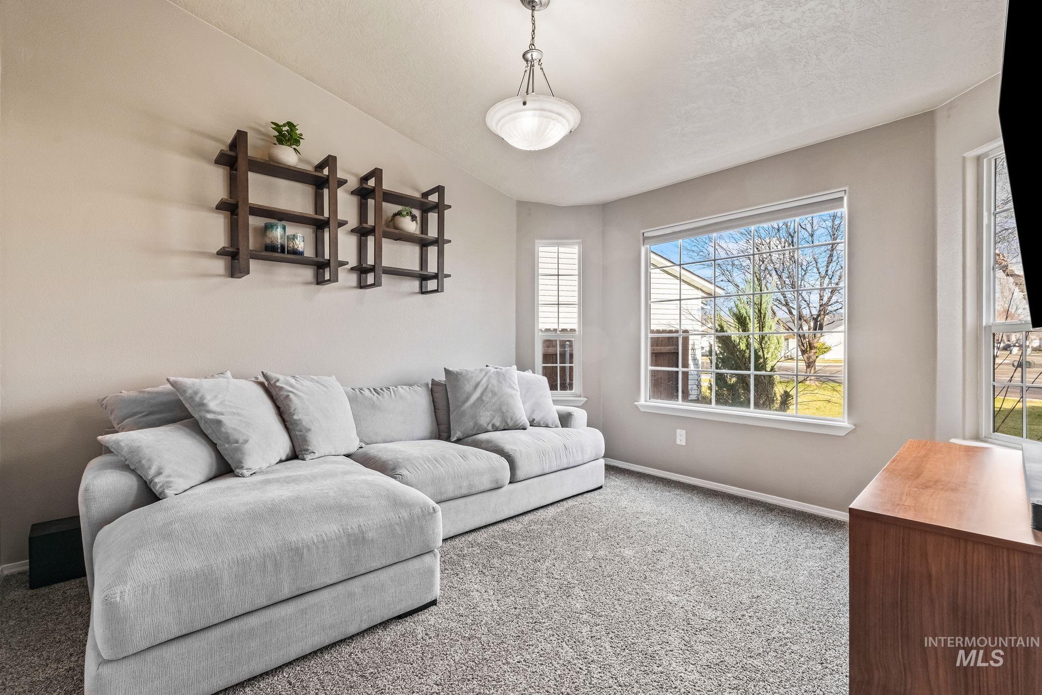 Living area with carpet floors and a textured ceiling