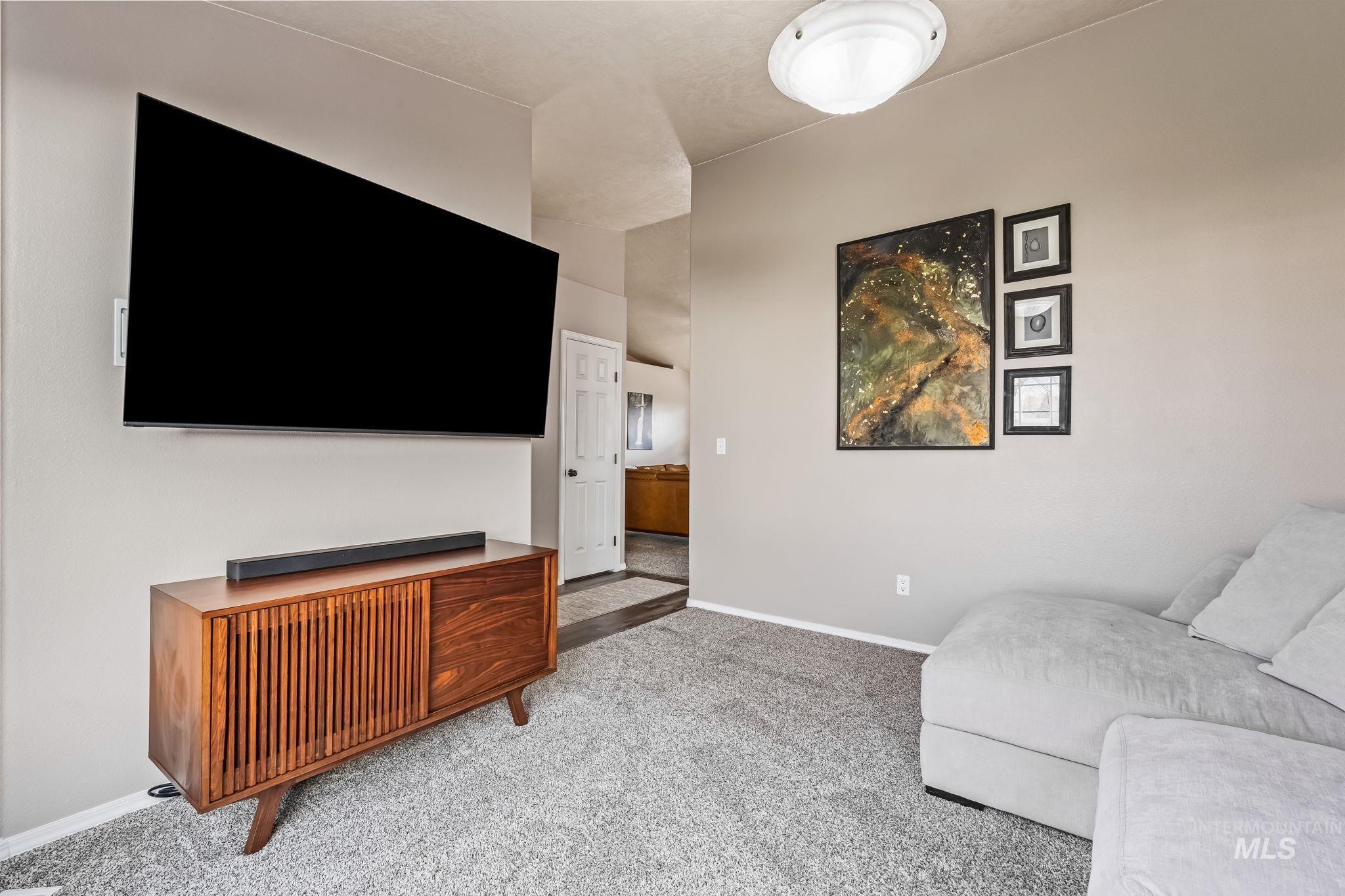 Carpeted living area with baseboards
