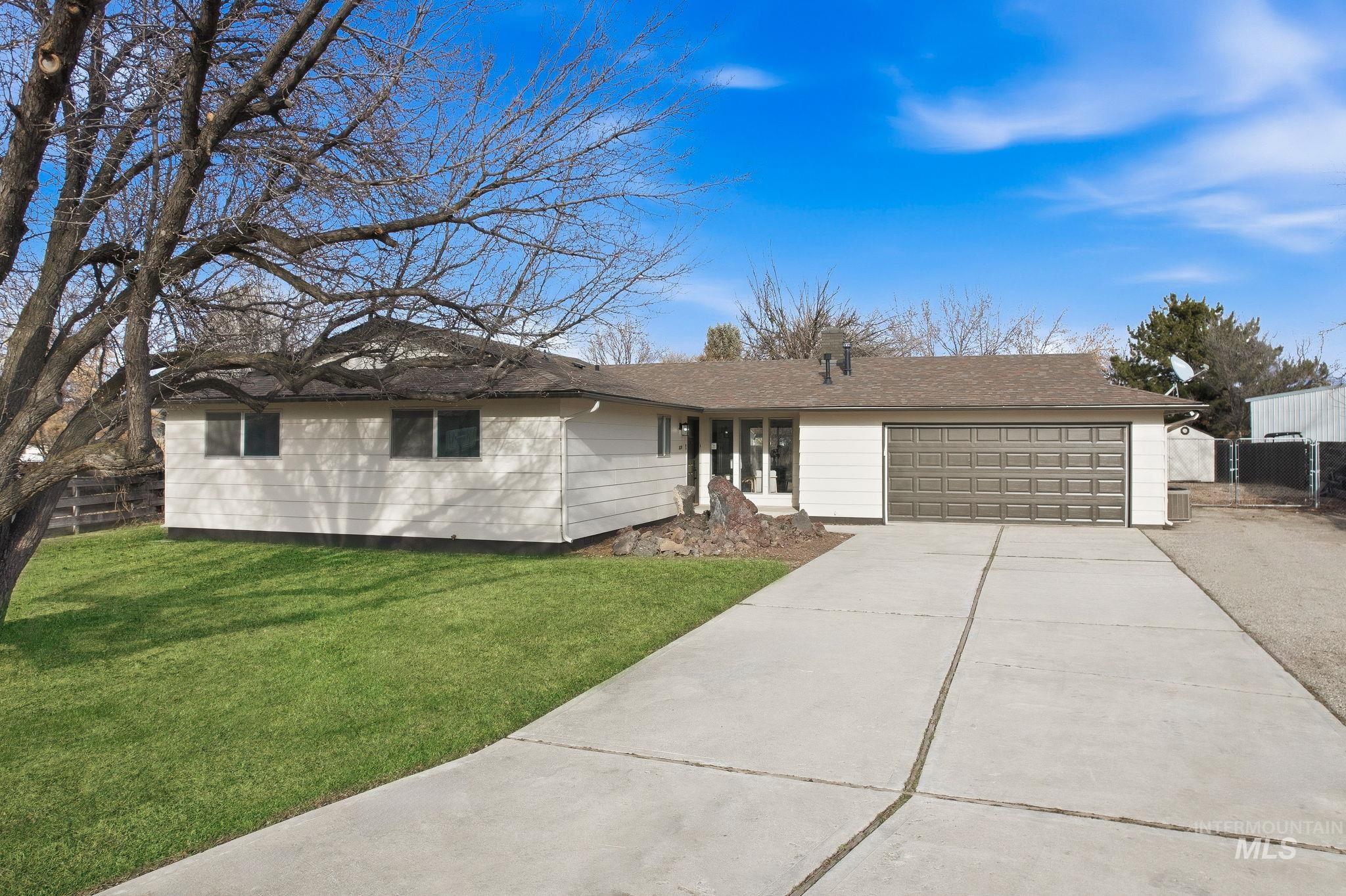 Ranch-style home featuring concrete driveway and an attached garage