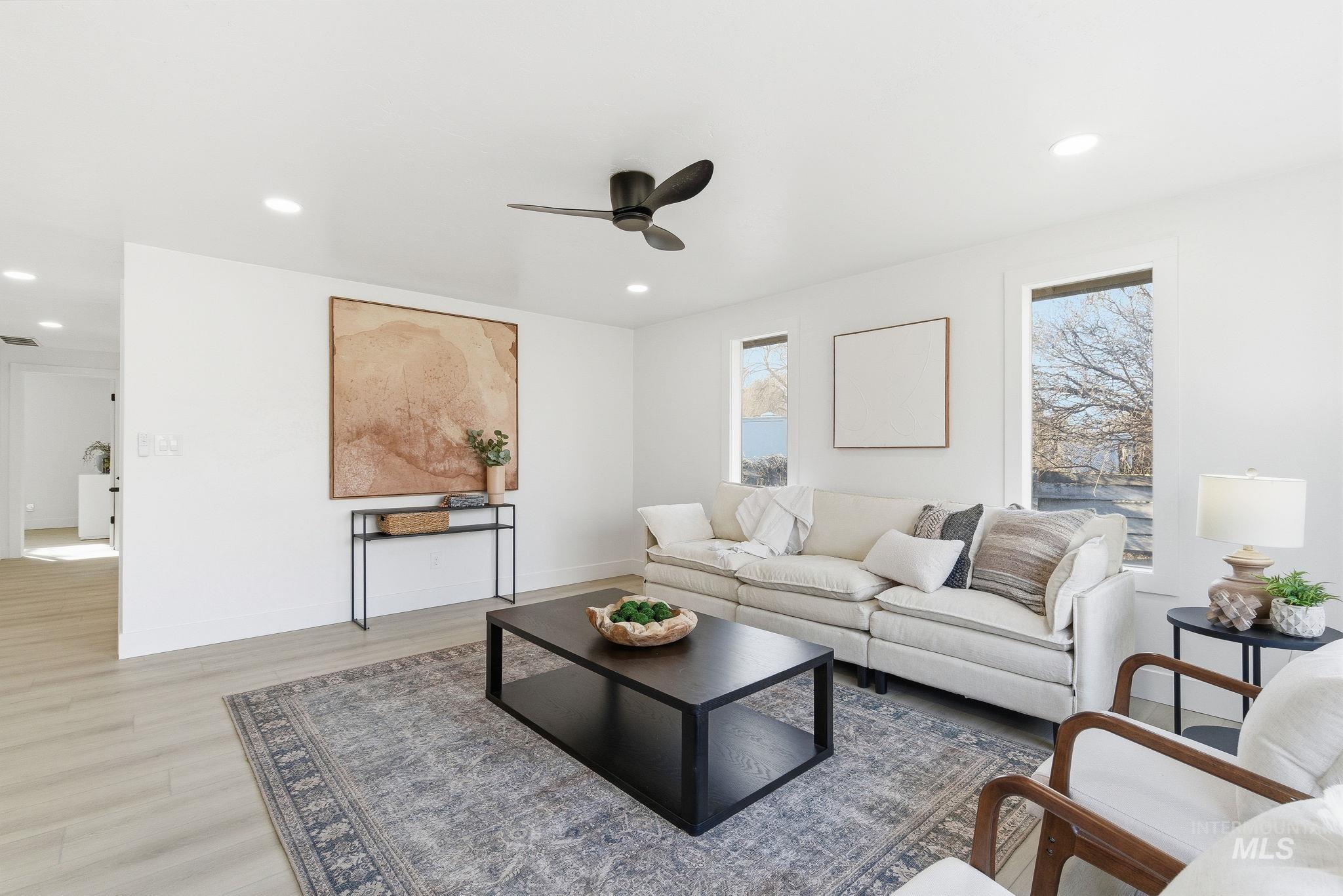 Living area with light wood finished floors, a ceiling fan, and recessed lighting