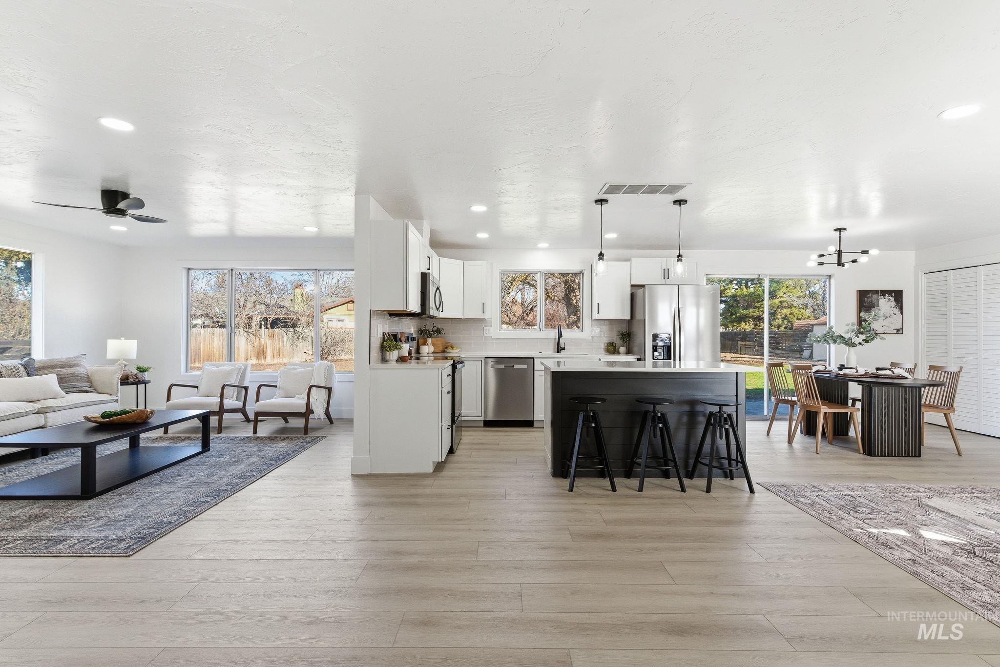 Living area with recessed lighting, a chandelier, a ceiling fan, and light wood-style floors