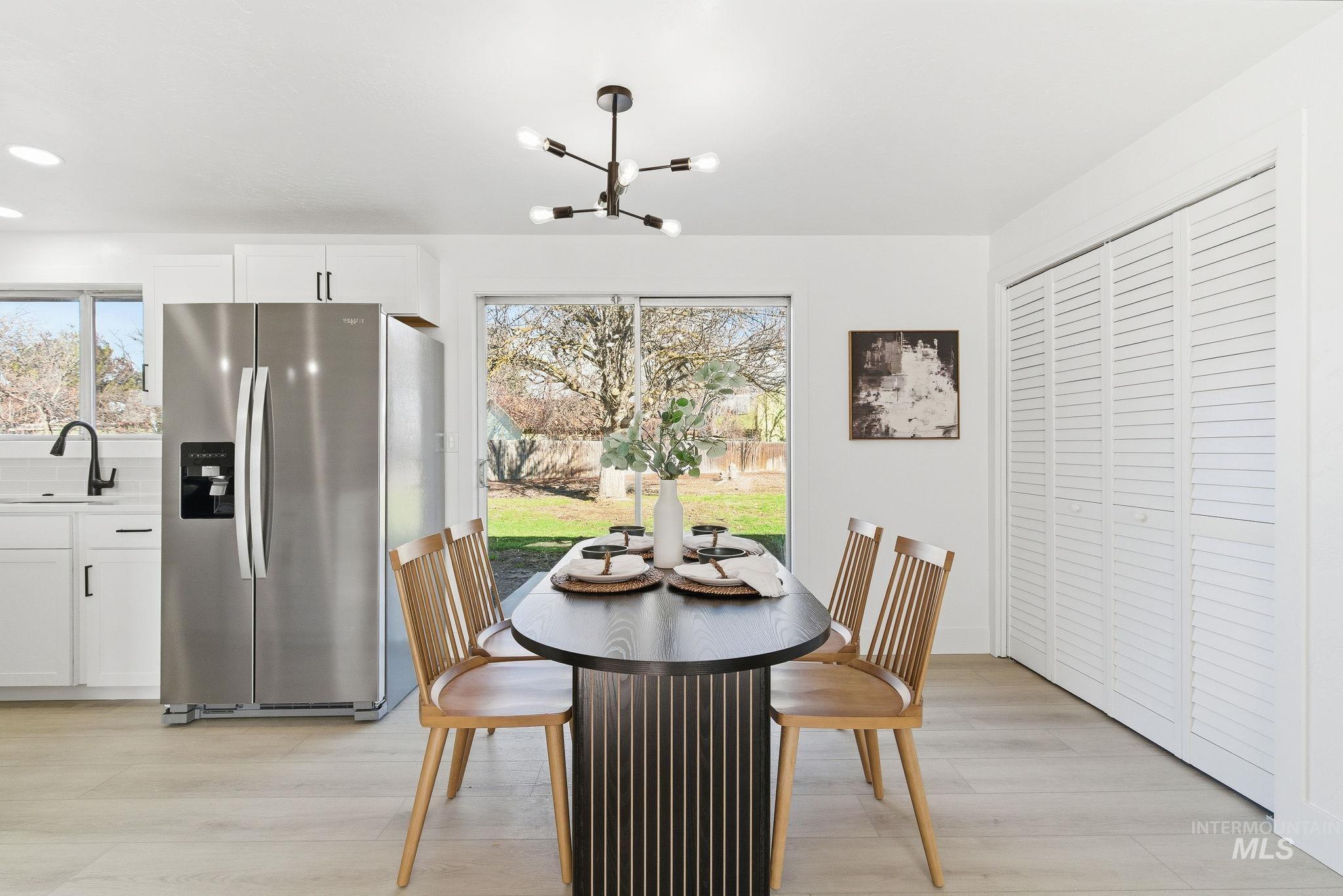 Dining area with plenty of natural light, a chandelier, and light wood-type flooring