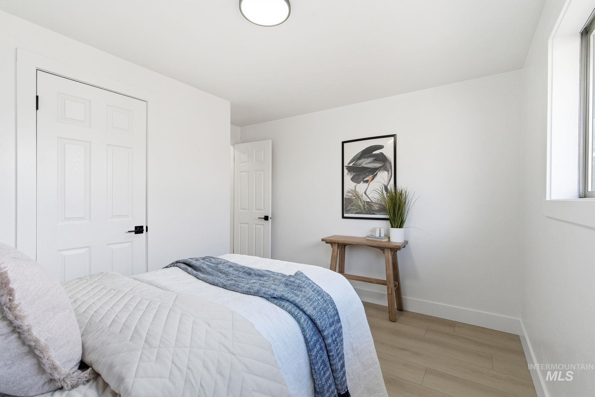 Bedroom featuring wood finished floors and baseboards