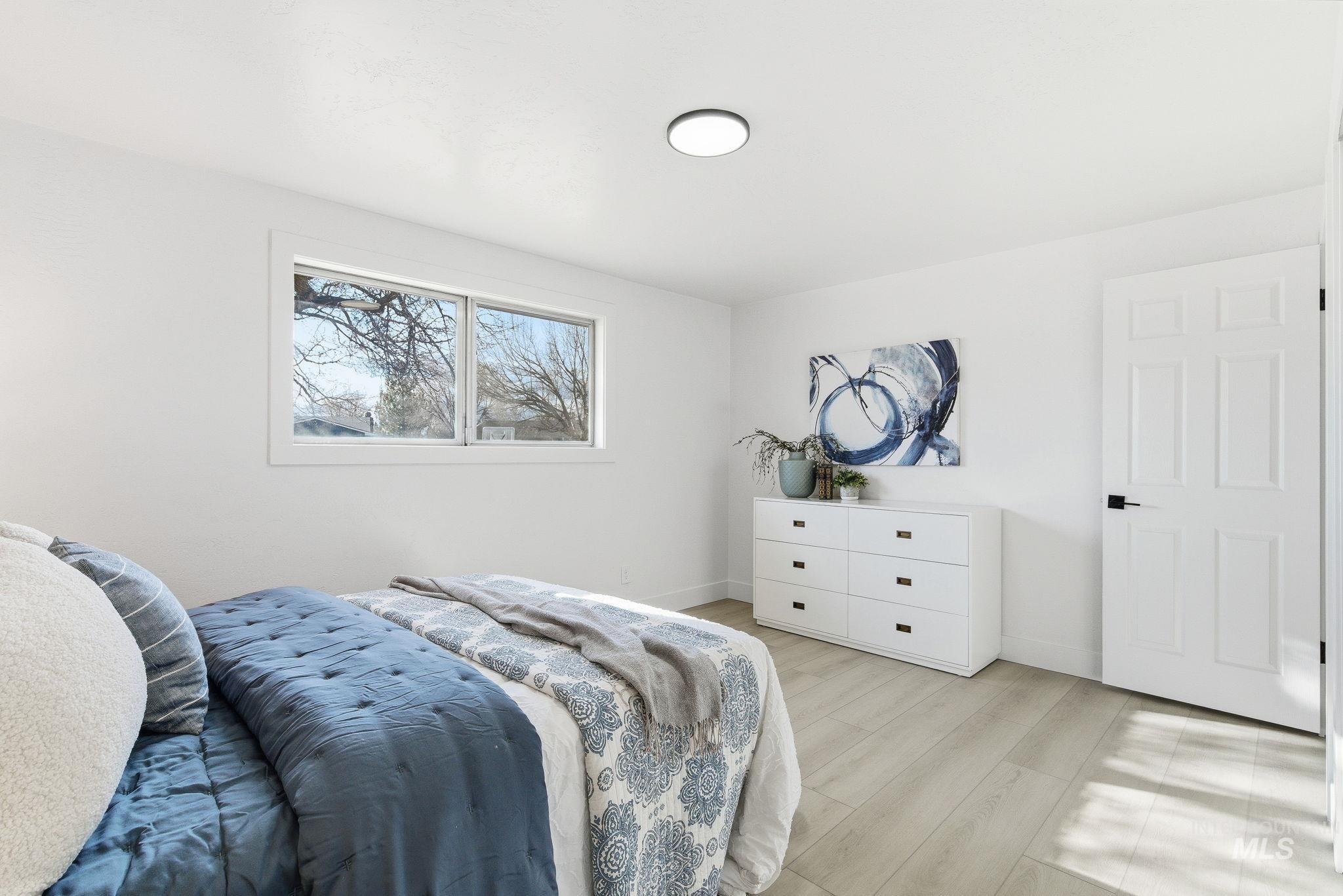 Bedroom with light wood-style floors and baseboards