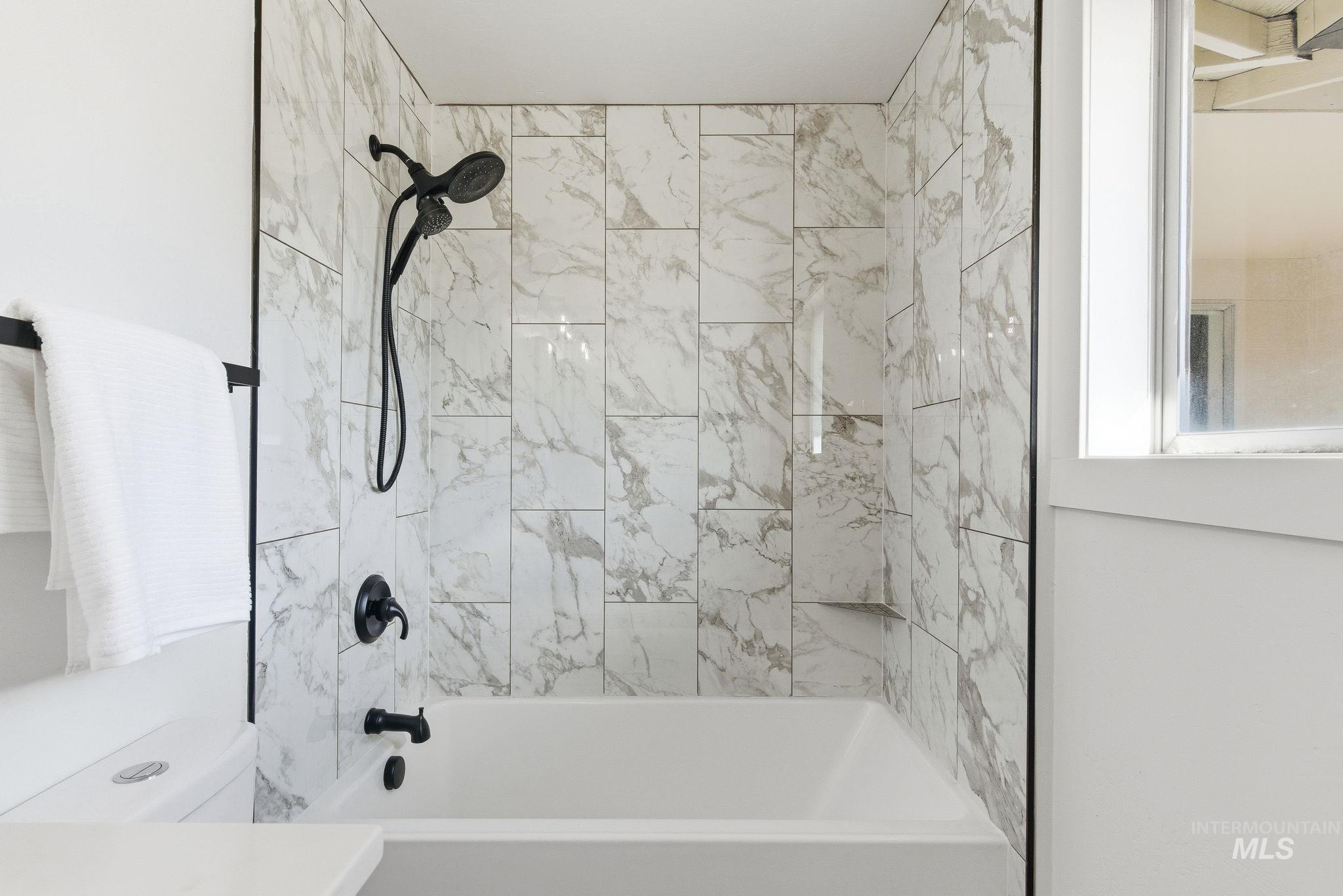 Bathroom with shower / bathtub combination and toilet