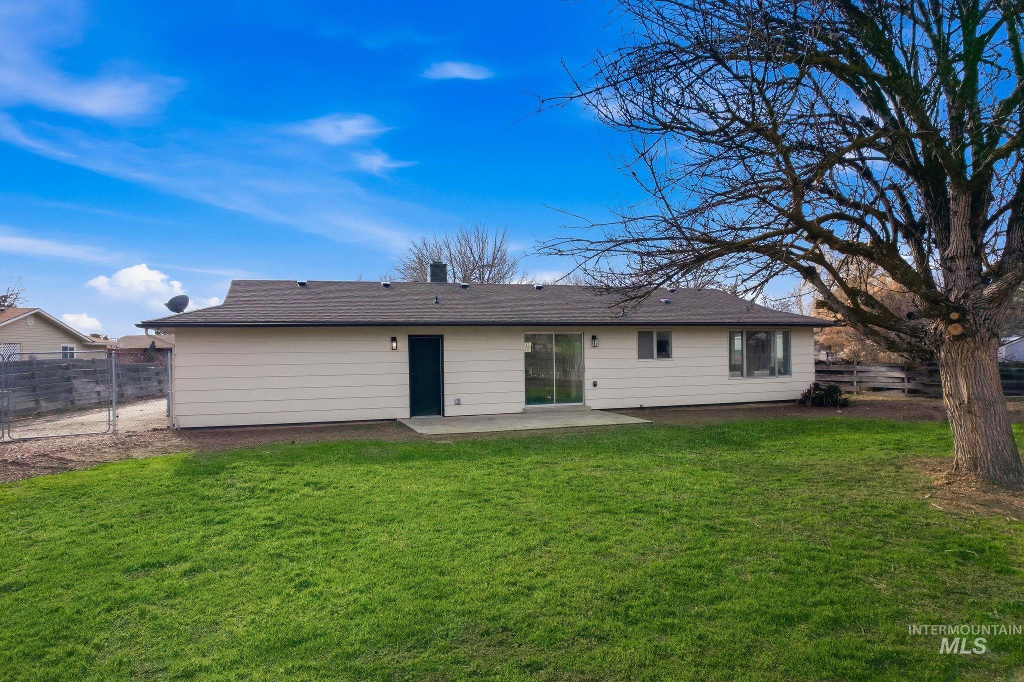 Back of house featuring a patio area, a fenced backyard, a chimney, and roof with shingles