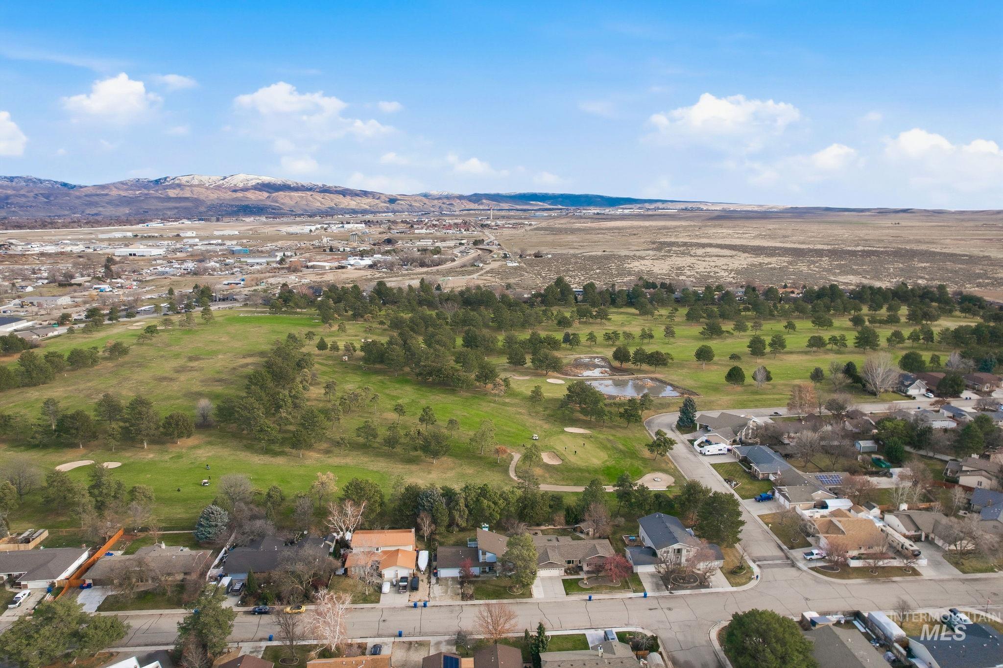 Aerial overview of property's location featuring nearby suburban area and a water and mountain view